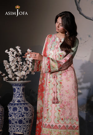 Asim Jofa AJCS-10 peach floral printed charmeuse silk suit – model arranging white blossoms beside a blue and white vase