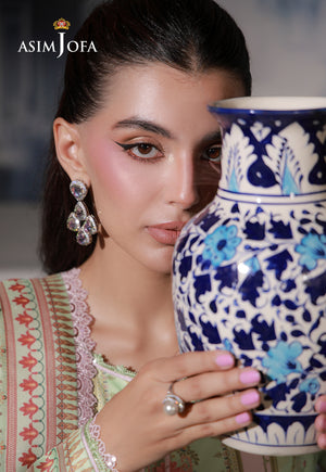 Asim Jofa AJCS-01 campaign portrait – model in mint green printed charmeuse silk holding a blue and white vase beside her face