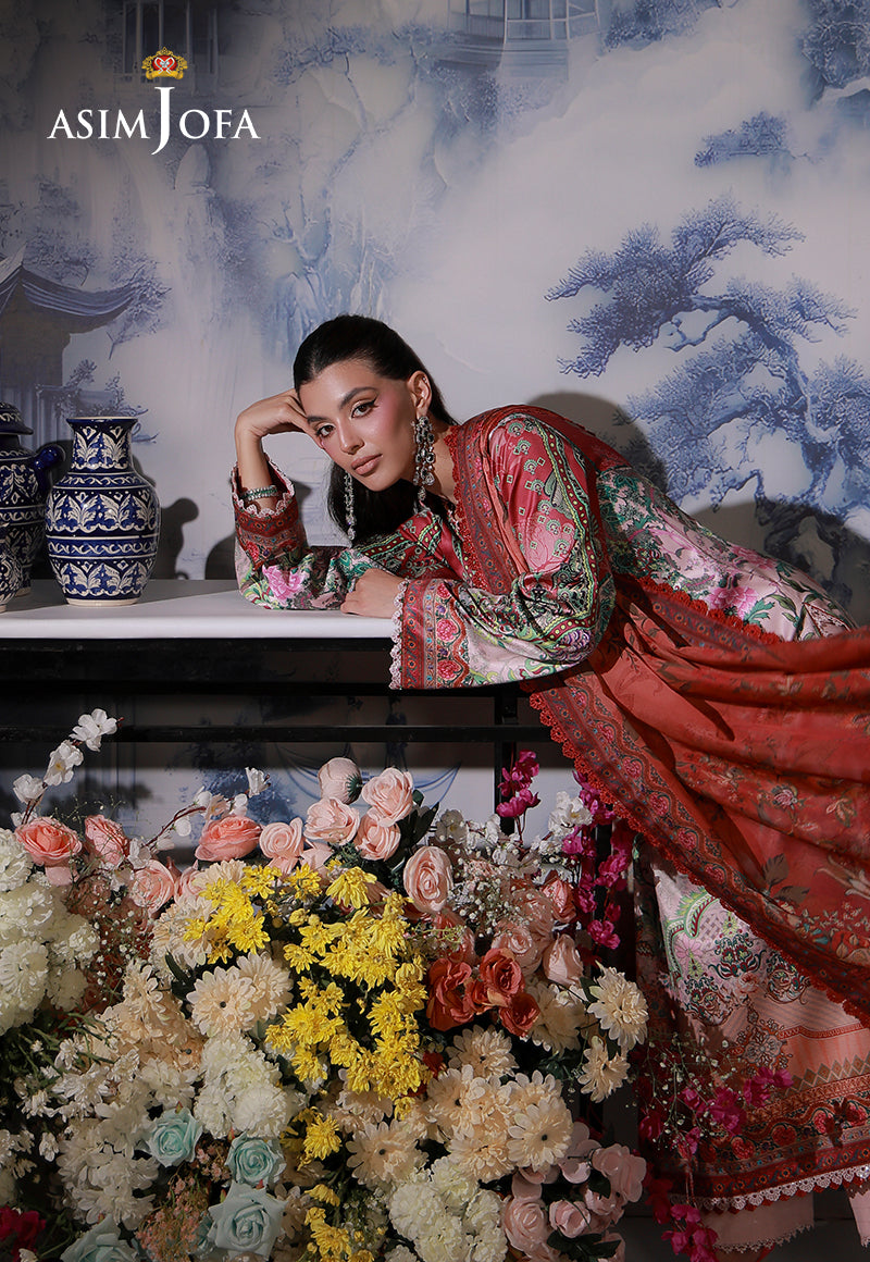 Asim Jofa AJCS-04 pink ombre printed charmeuse silk suit – leaning portrait beside flowers, highlighting patterned sleeves